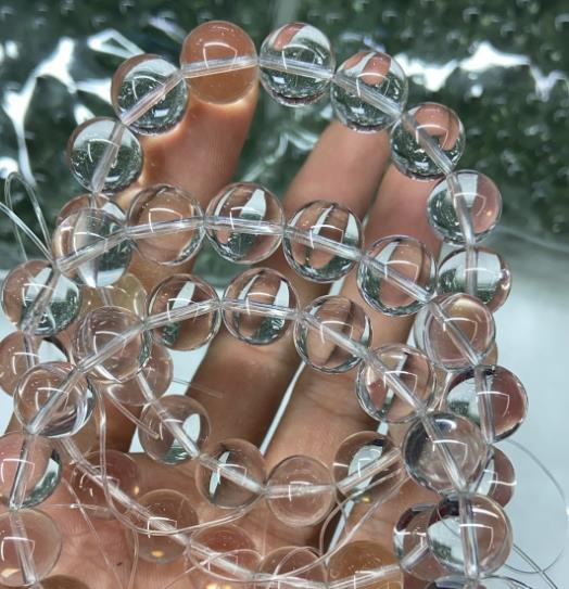 Clear quartz bead strands held in hand