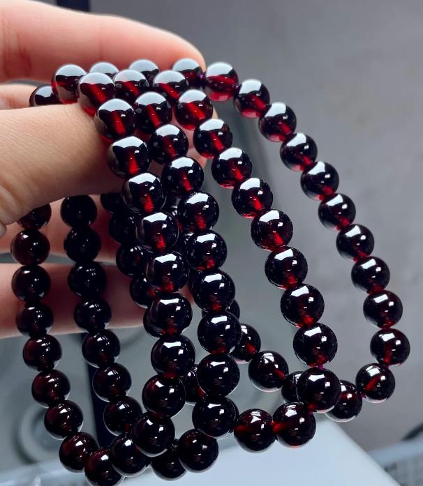 Garnet bead strands in deep red held up to the light